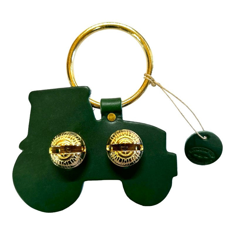 a door hanger bell in green leather stamped in the shape of a tractor in profile - includes 2 brass bells in the center and a brass loop for hanging on a door