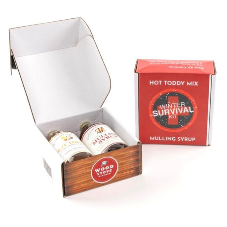 the winter survival kit showing 2 boxes: one open so you can see the bottles of mulling syrup and hot toddy mixer inside, and one closed so you can see the logo on the box