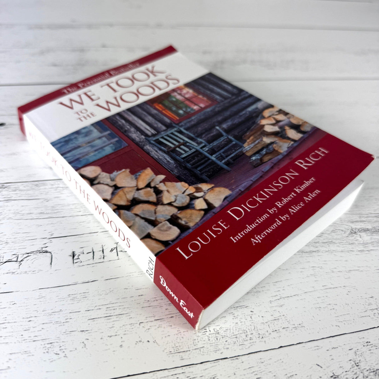 We Took to the Woods book on rustic white wood, shown at a slight side angle so the spine is visible