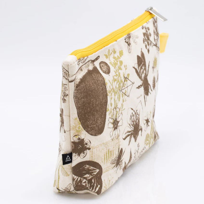 a side angle of white canvas zipper pouch with vintage illustrations of honey bees