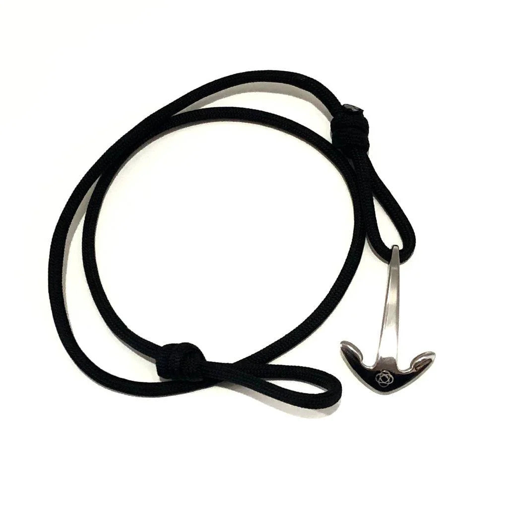 a black cord wrap bracelet with silver anchor charm unwrapped in a loose circle showing the nearly unwrapped length of the bracelet