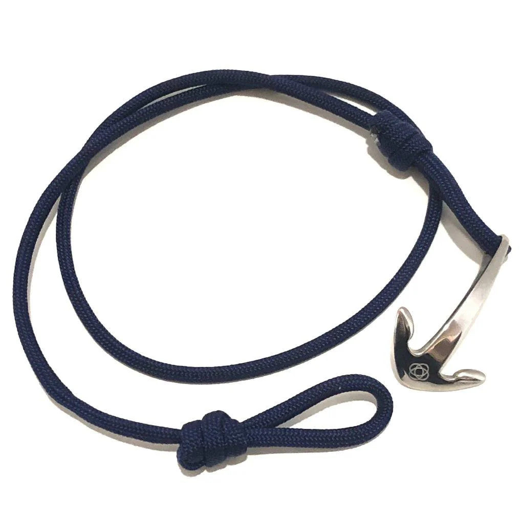 a navy blue wrap bracelet with silver anchor charm unwrapped in a loose circle showing the nearly unwrapped length of the bracelet