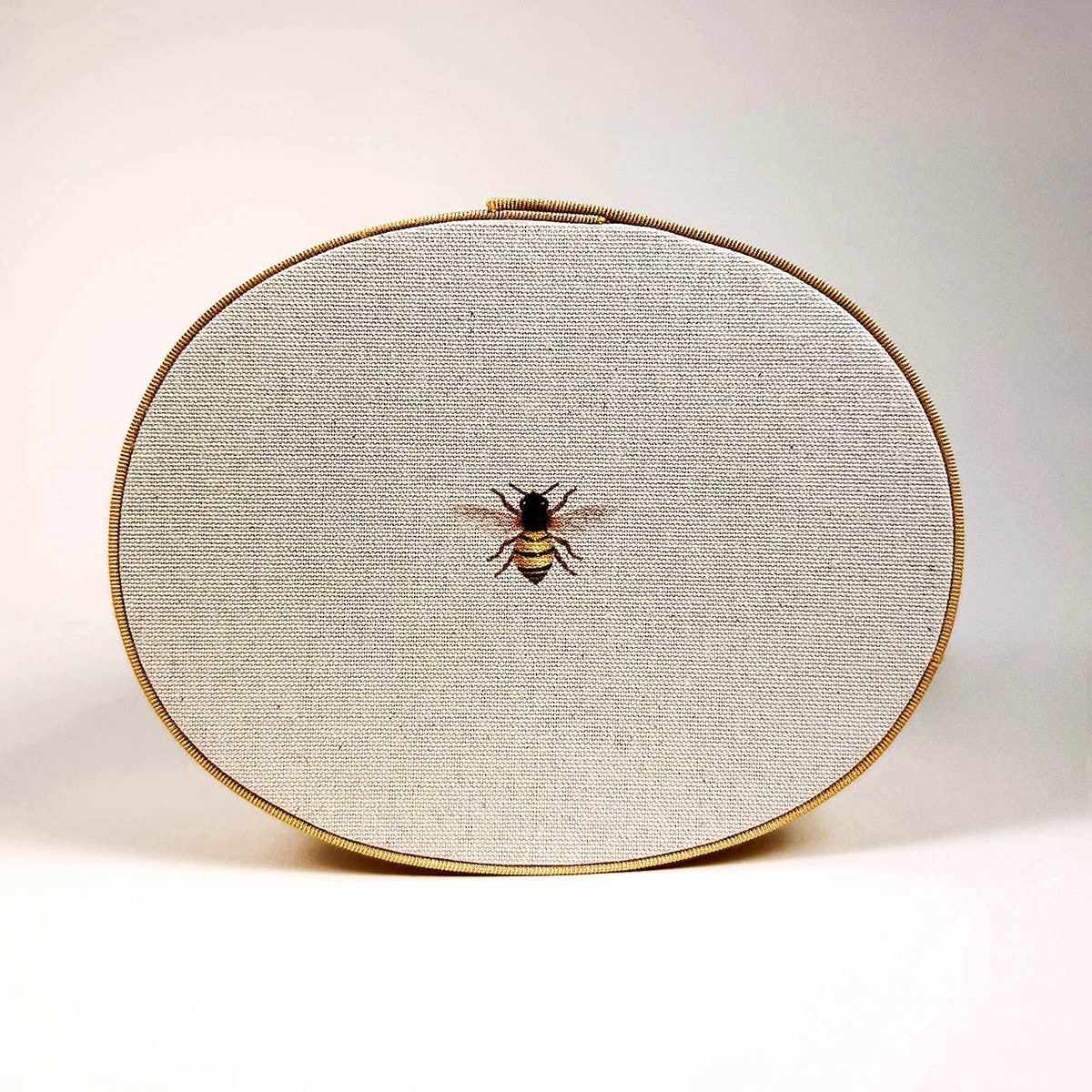 a close up of the hat box lid with bee design in the center of the lid