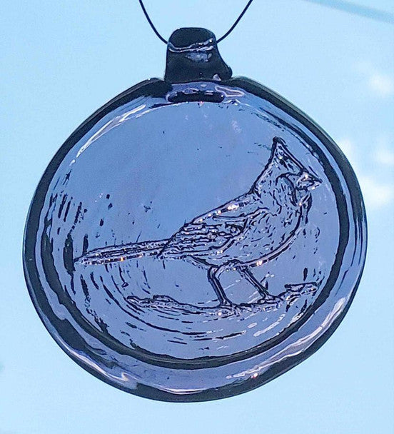 a light purple, round glass suncatcher with a relief image of a cardinal