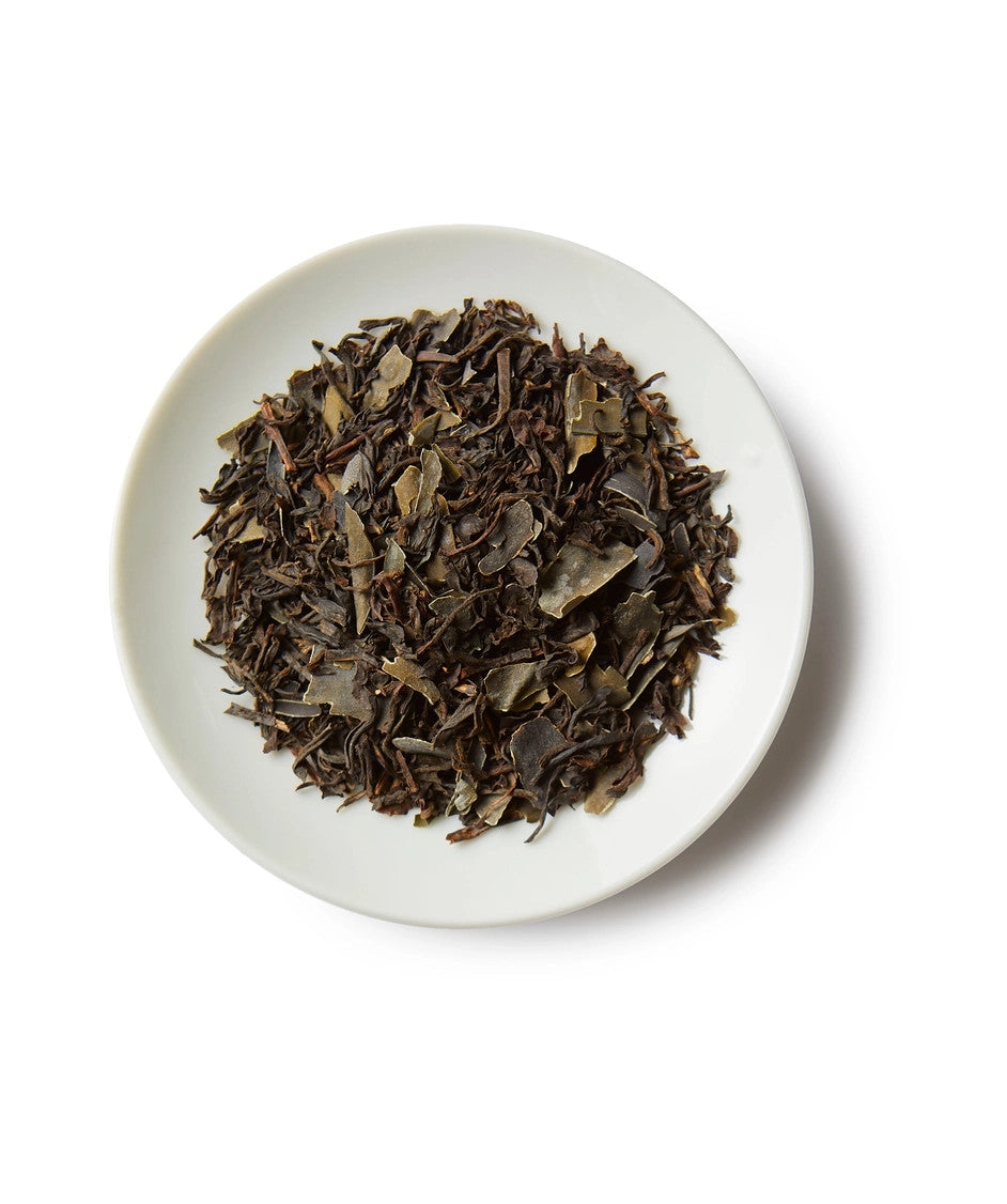 a small white round dish containing a mound of bold coast breakfast loose leaf tea showing the black tea and kelp ingredients