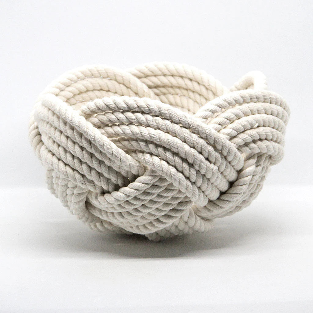 a hand woven cotton rope bowl in white against a white background