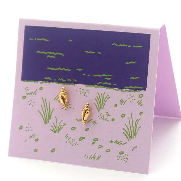 petite gold conch shell stud earrings on a light purple backer card