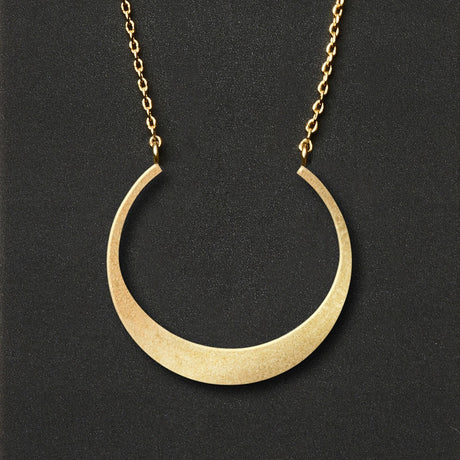A gold necklace with a crescent moon pendant