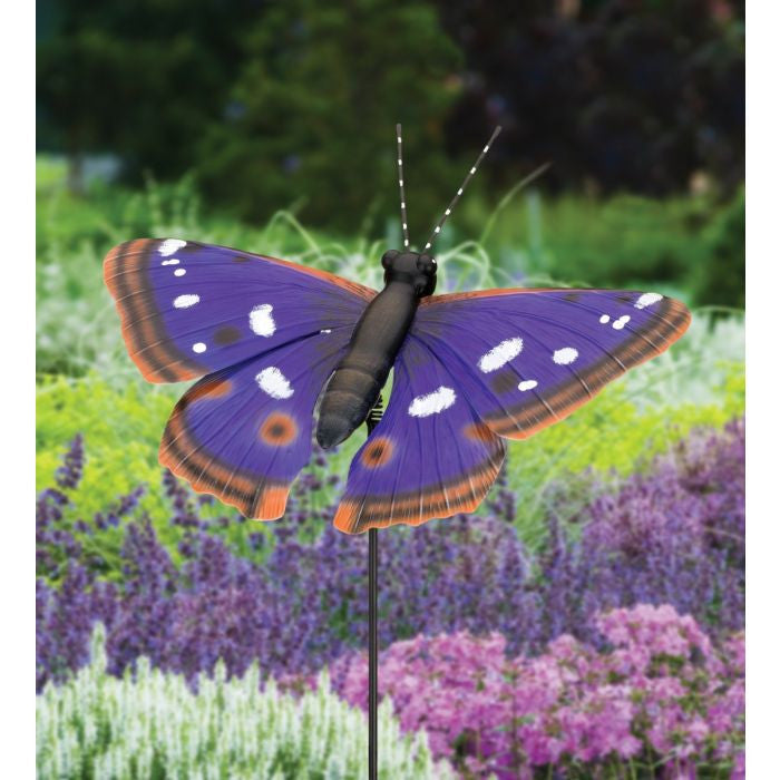 a metal, purple, emperor butterfly stake in a lush garden