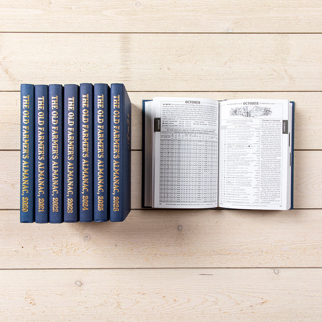 Set of 'The Old Farmer's Almanac' books on a wooden surface with one book open