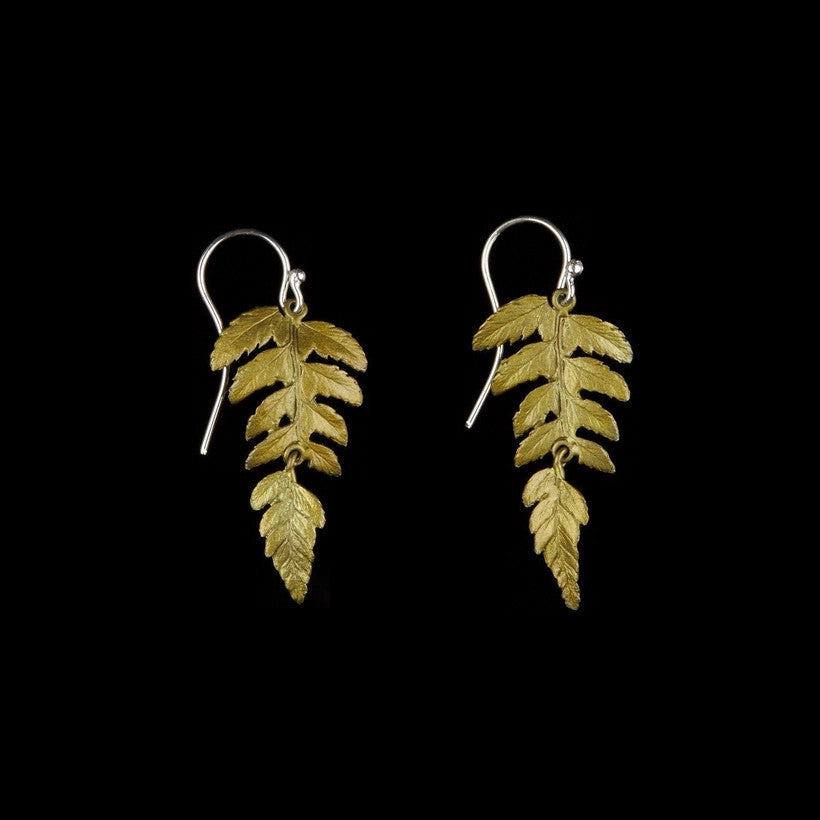 a pair of earrings bronze cast from real fern leaves with green patinated leaves hanging from silver earring wire