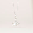 an intricately detailed pewter ginkgo leaf shaped pendant hanging from a silver chain