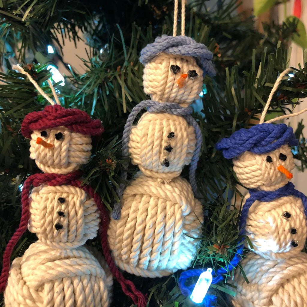 a group of handmade snowman ornaments hanging on a tree