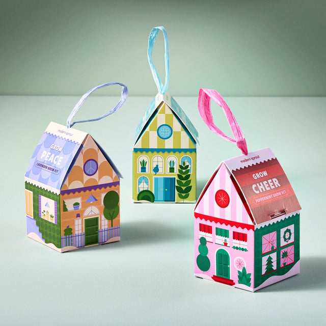 a trio of colorful house shaped ornaments with satin ribbons to hang on a tree