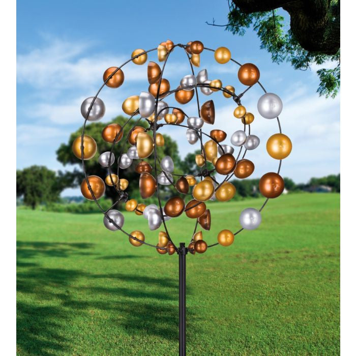 Image of the Spinner in a Garden Setting: The Gyroscope Wind Spinner displayed in a garden, emphasizing its impressive 7-foot height and eye-catching metallic shine amidst the natural surroundings.