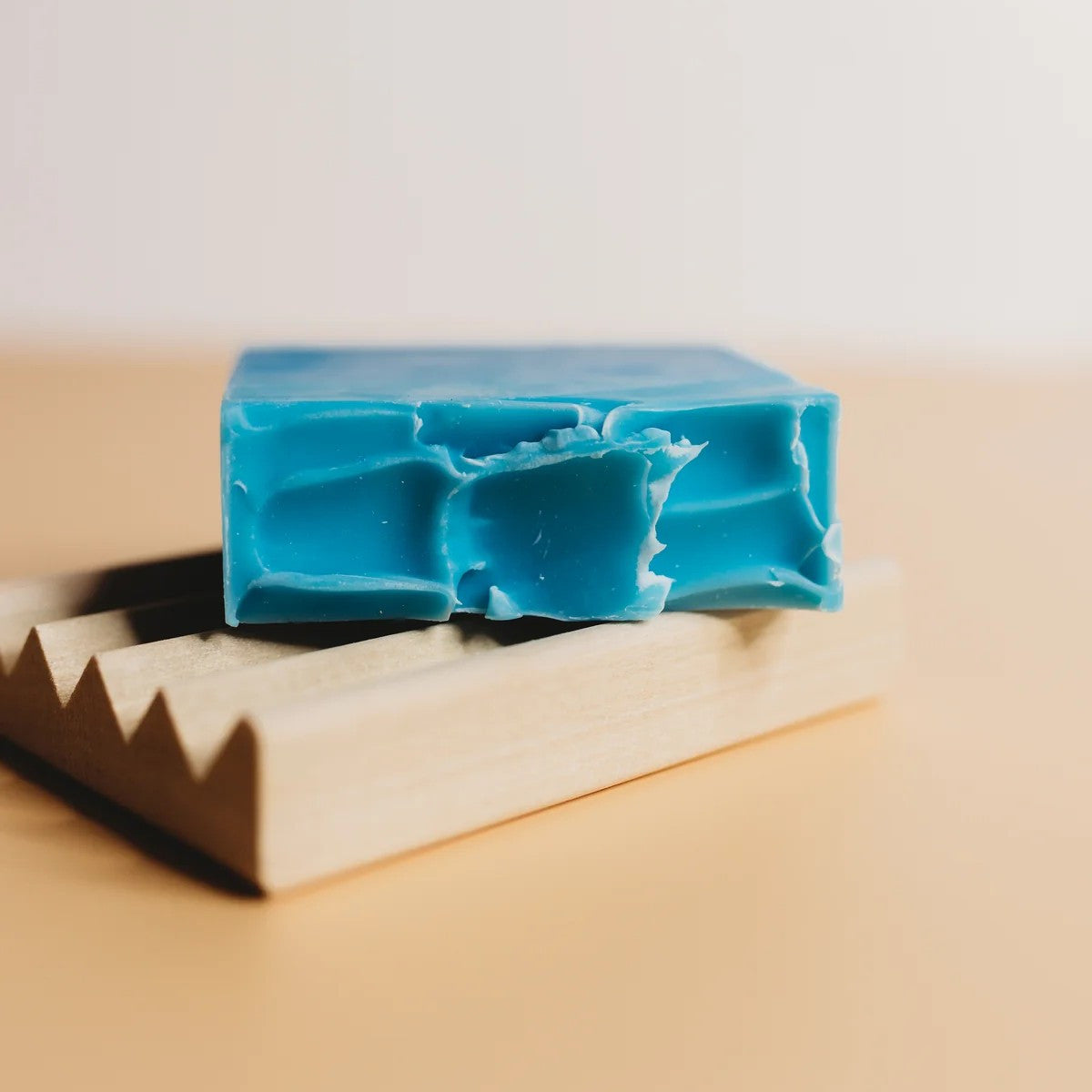the high tide soap laying flat on a wooden soap dish