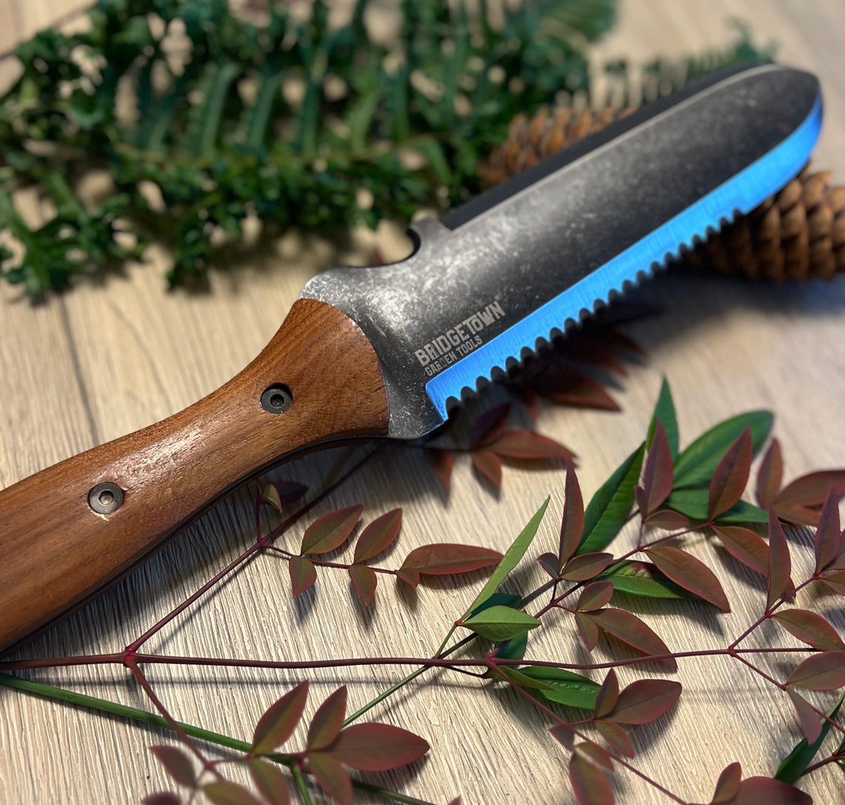 Essential Hori Hori knife on a table with freshly cut greens