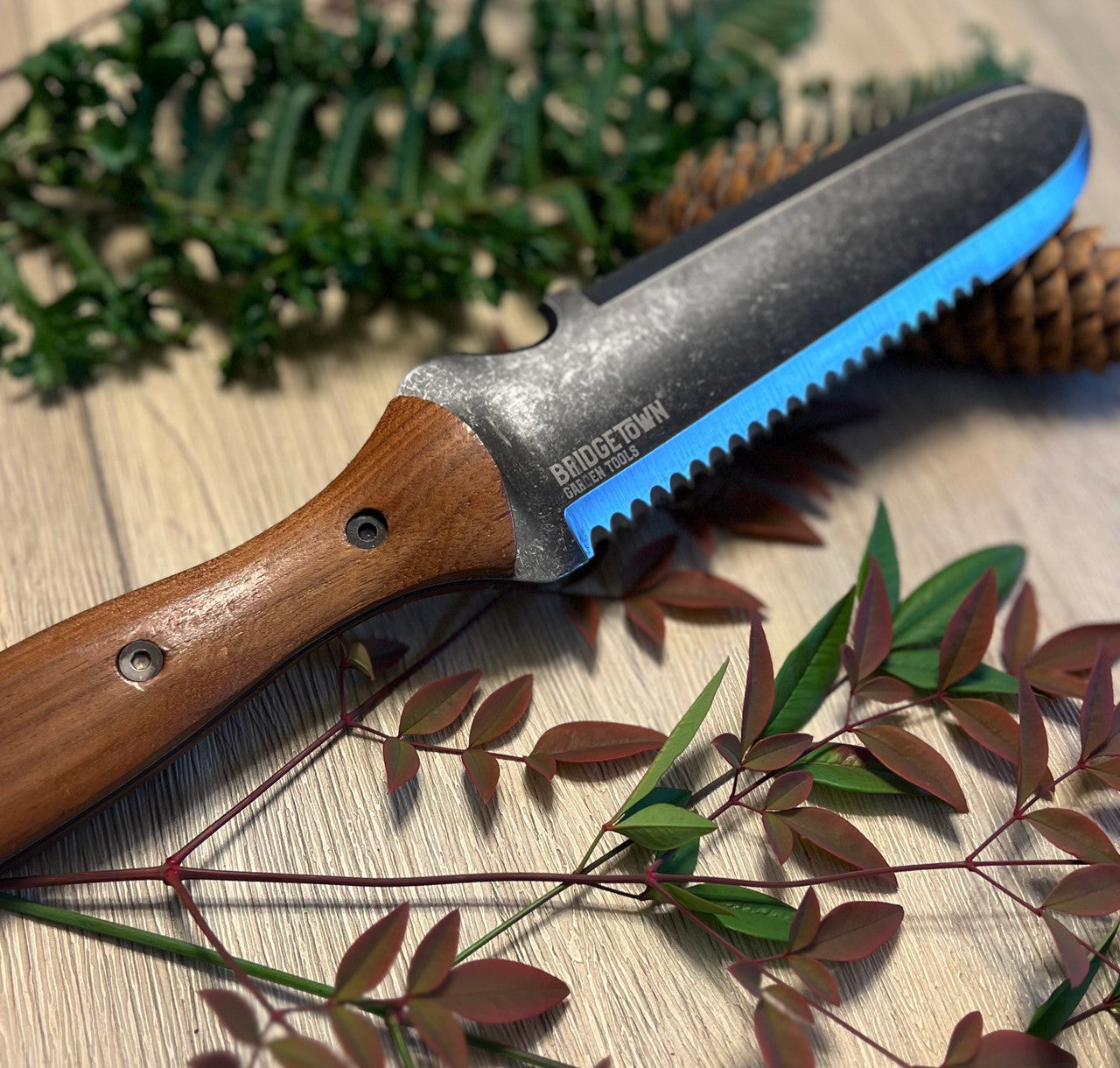 Essential Hori Hori knife on a table with freshly cut greens