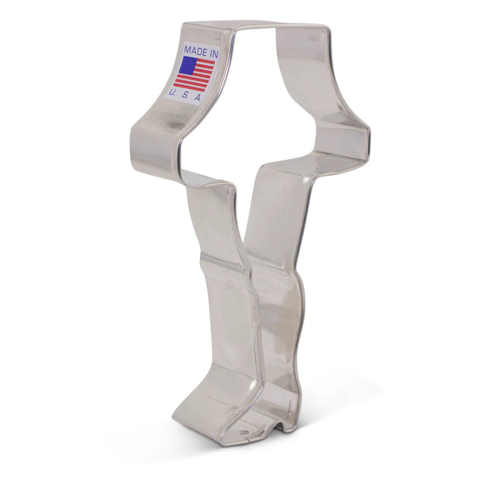 a tin cookie cutter in the shape of a leg in high heels topped with a lampshade