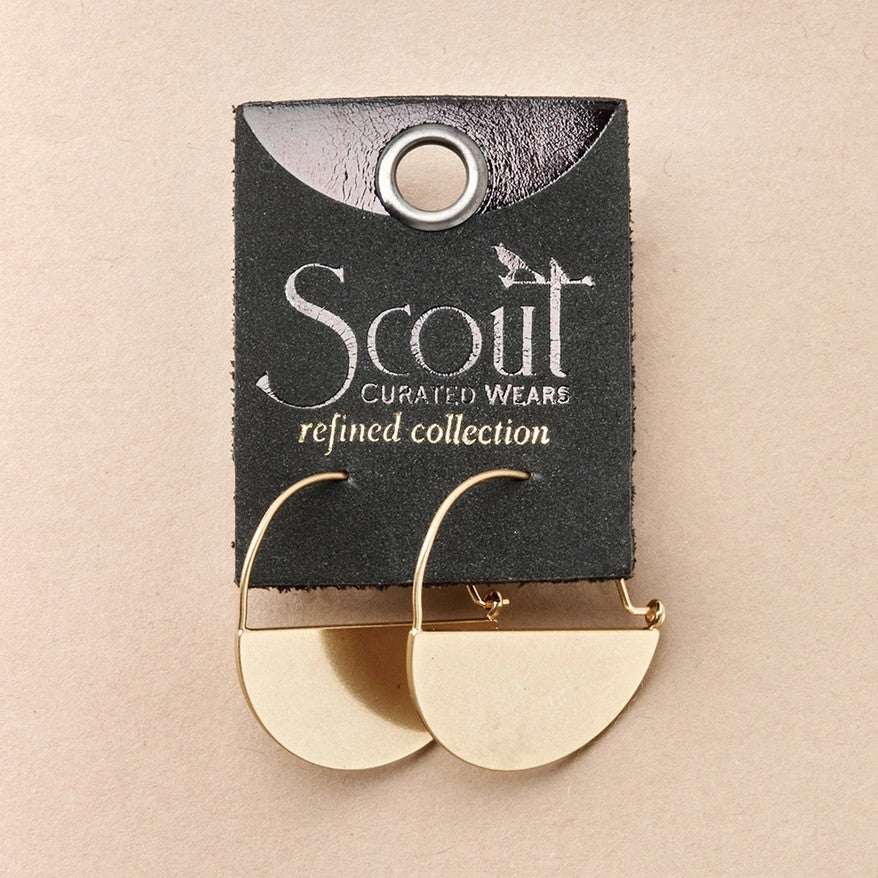 a pair of gold hoop earrings that form a half circle like a half full moon on a leather card with gold foil