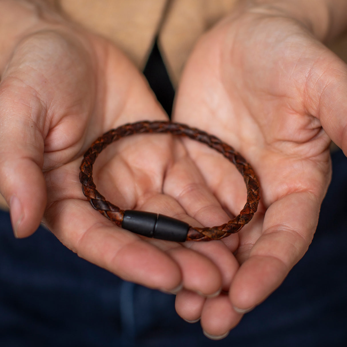 a pair of hands holds the braided moose leather bracelet