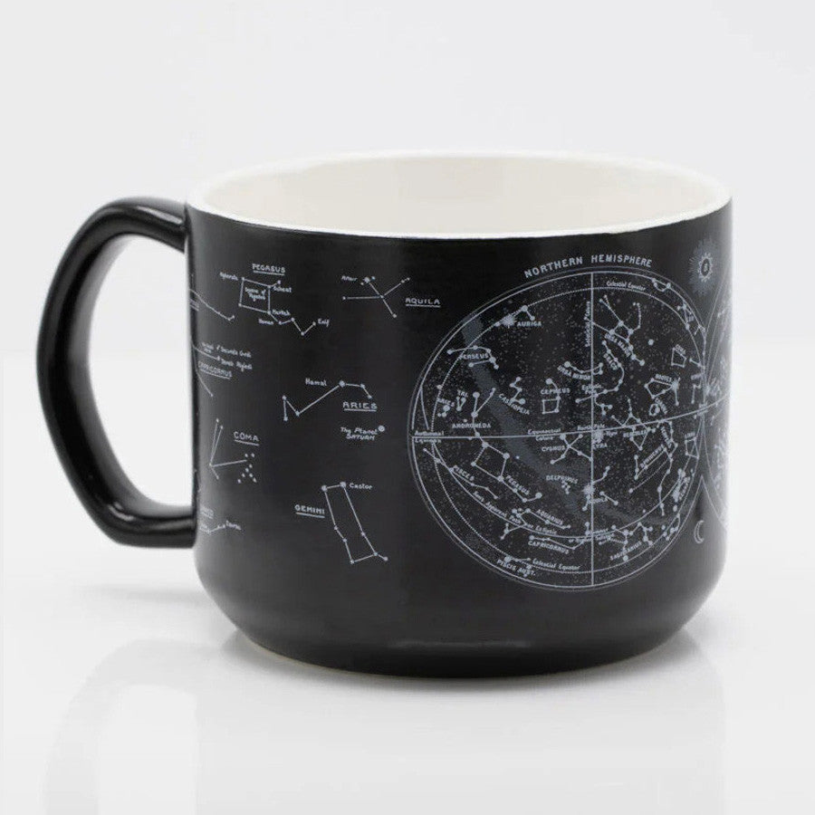 a Black coffee mug with printed astronomy charts of the night sky.