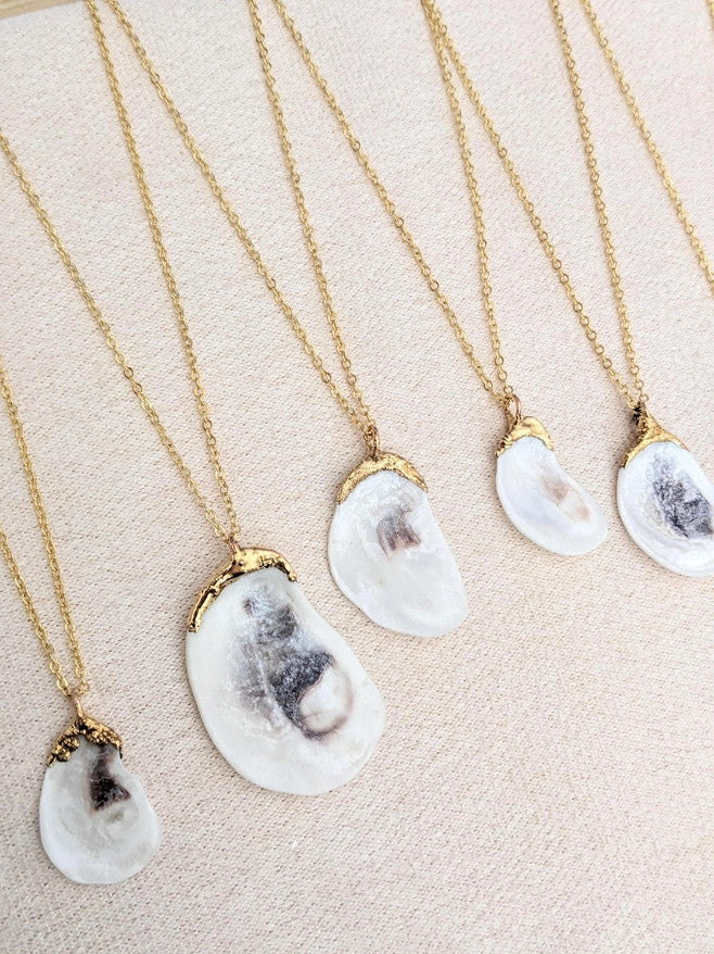 a grouping of 5 Oyster Shell necklaces to show the variation in shell size as well as unique qualities that occur with every shell