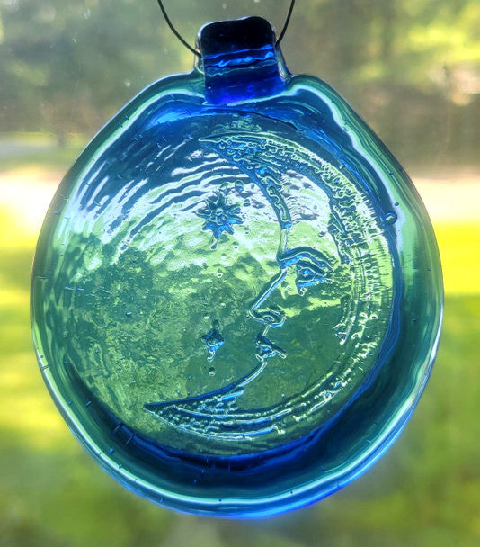 Blue glass suncatcher with a crescent moon design.