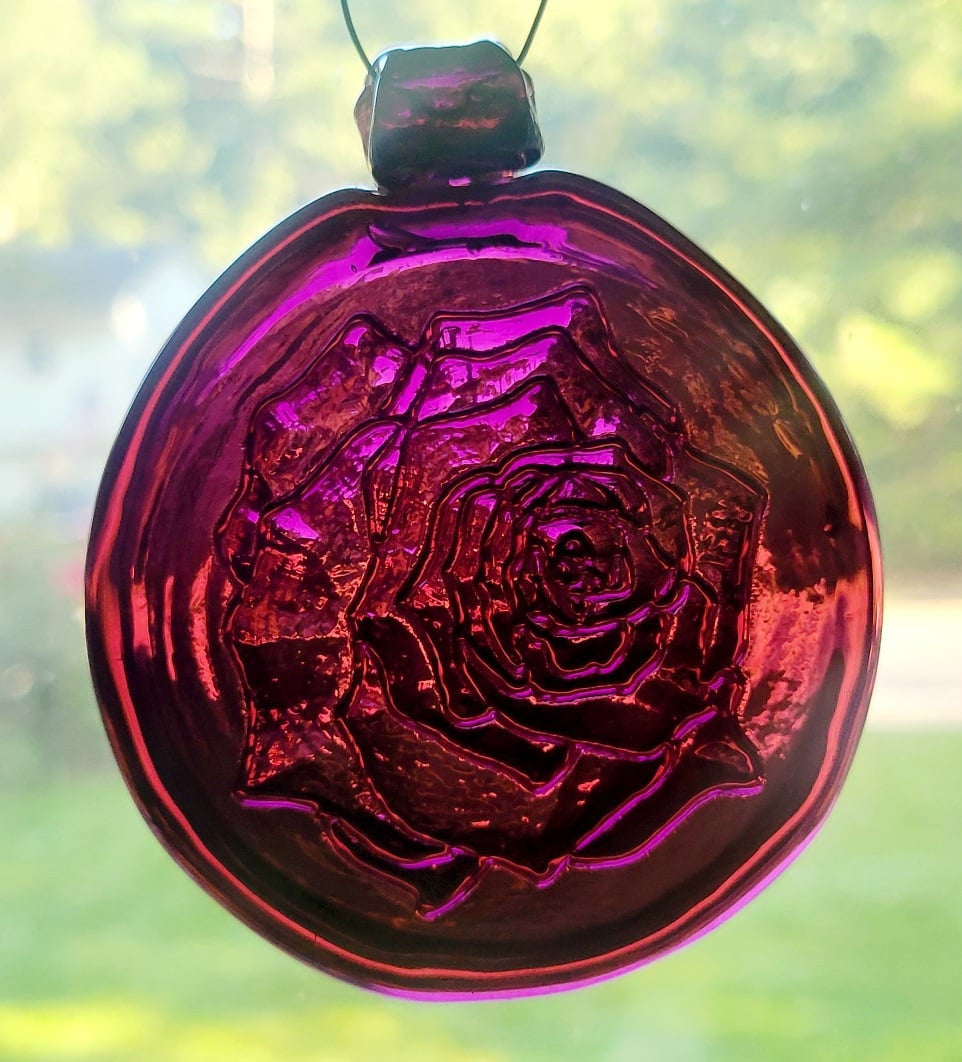 Purple glass suncatcher with a rose design.