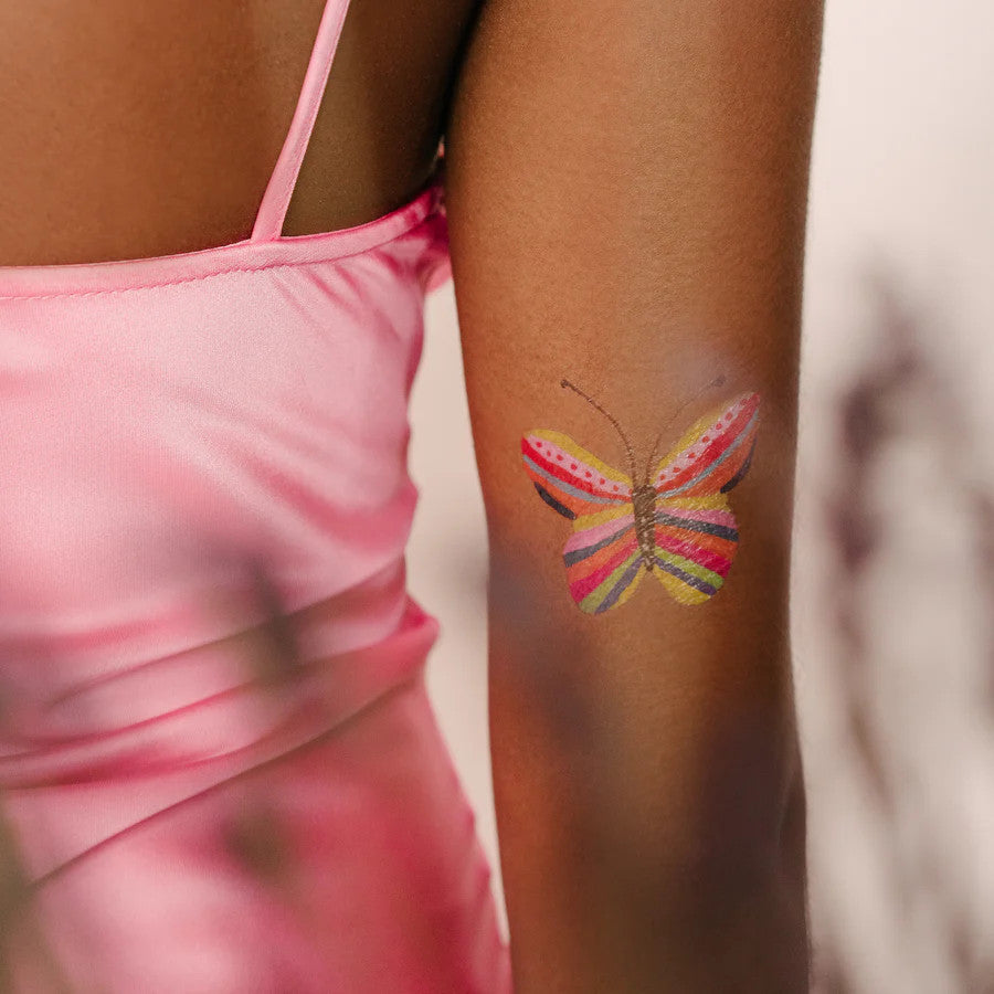 a model's inner forearm with one of the butterfly tattoos applied