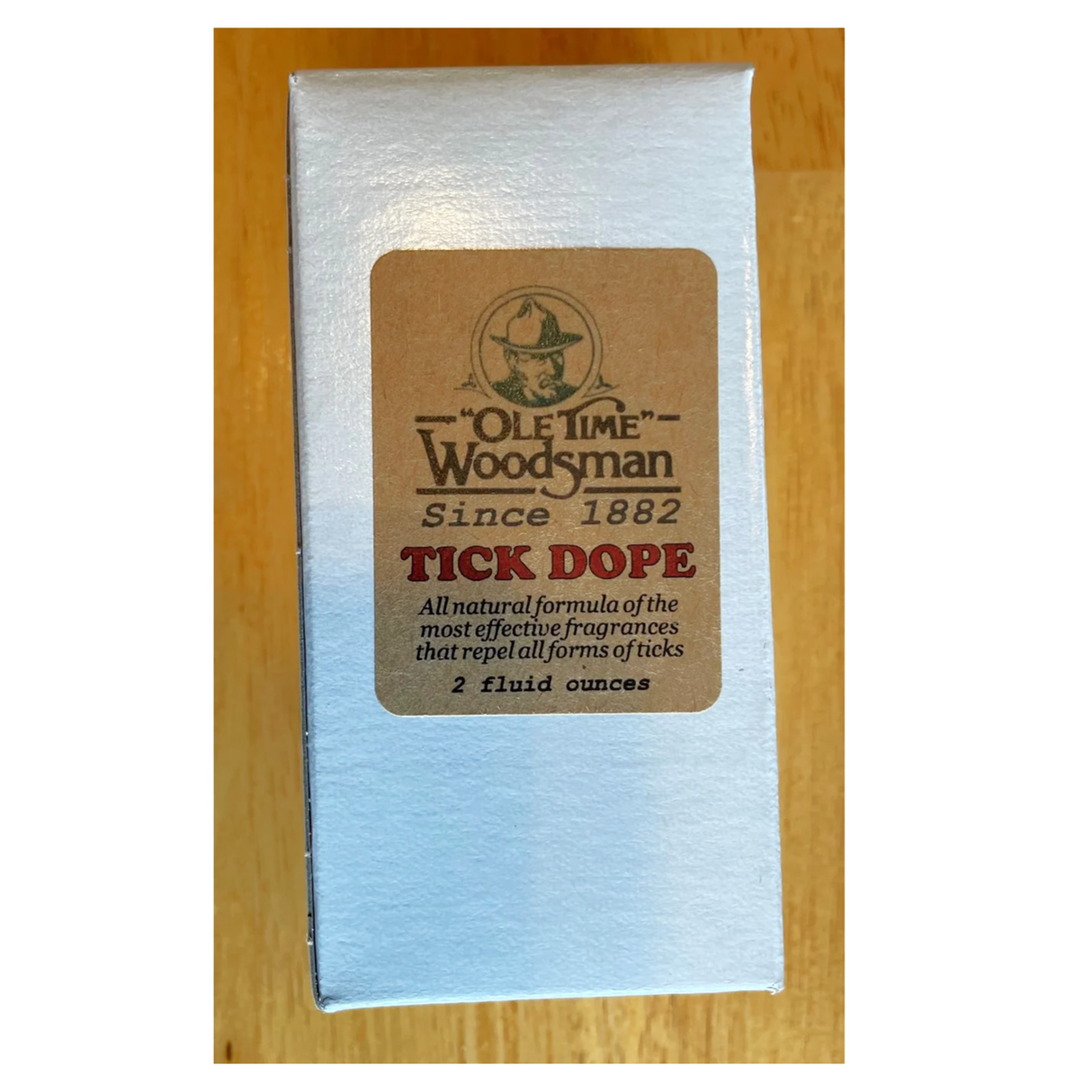 the white tick dope box with kraft label against a maple wood background