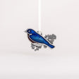 Decorative bluebird ornament with blue wings and silver body on a white background