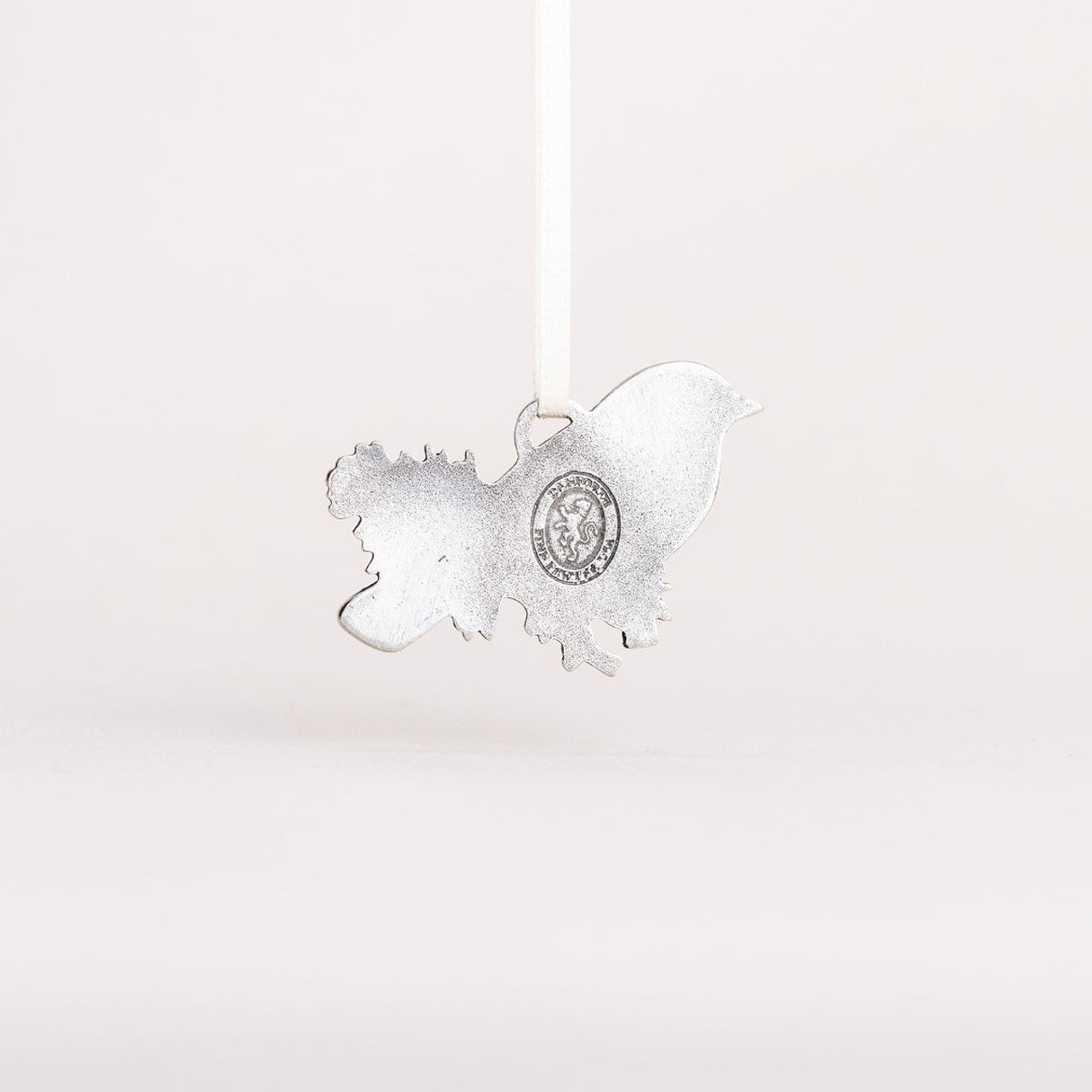 the backside of the Bluebird ornament showing the pewter material and Danforth Pewter maker's seal