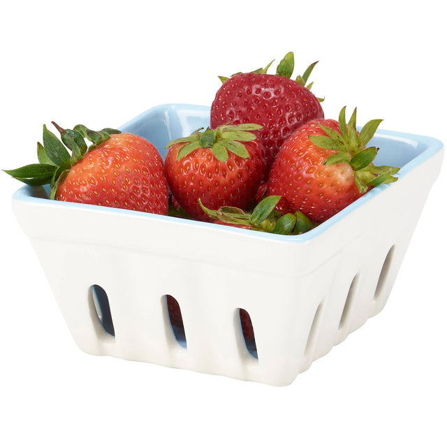 White ceramic berry basket filled with strawberries on a white background