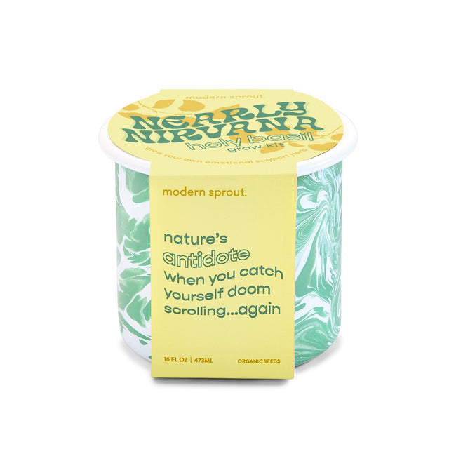 An enamel mug with a green and yellow packaging wrap featuring text about the product being a 'nature's antidote' and 'Modern Sprout' branding.