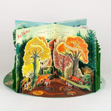Pop-up book showing a forest scene with autumn trees and animals on a white background