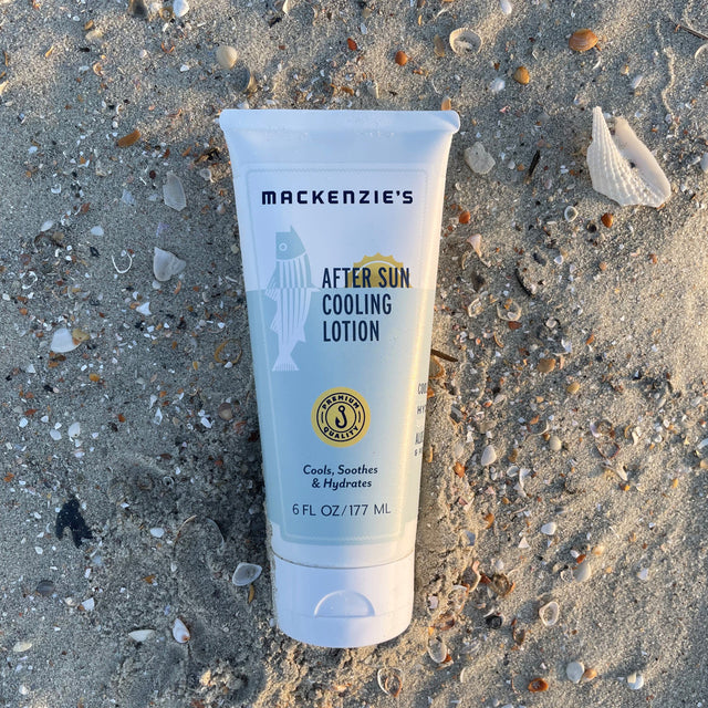 a bottle of after sun cooling lotion on a sandy beach