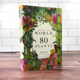 Book titled 'Around the World in 80 Plants' with colorful plant illustrations on a wooden surface.