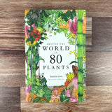 Book cover of 'Around the World in 80 Plants' on a wooden surface
