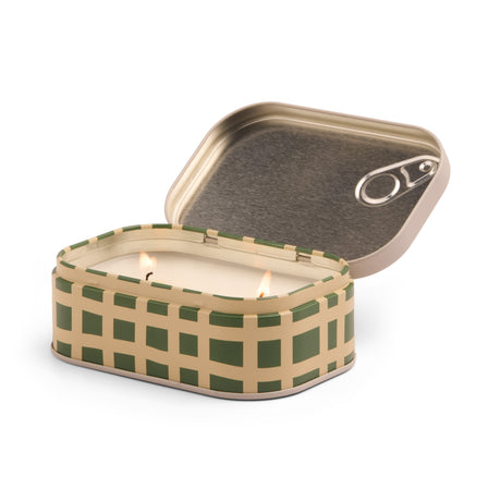 Candle in a checkered tin with a lid on a white background