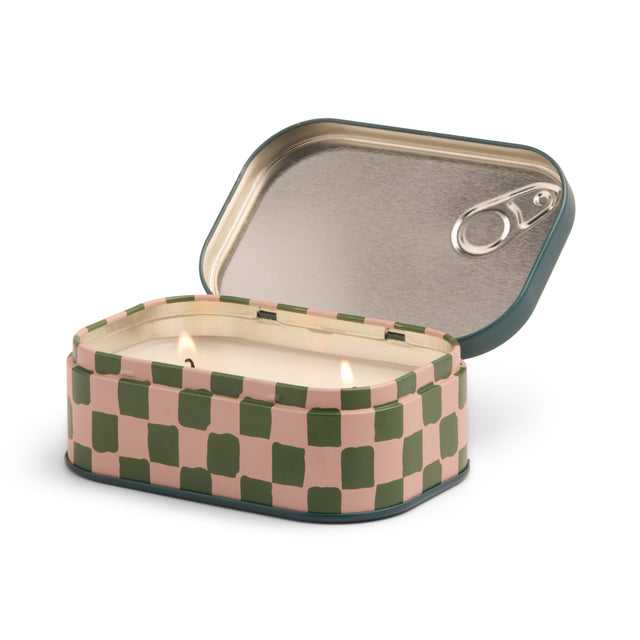 Checkered patterned candle in a tin can with a lit wick on a white background