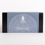 Curio Spice Co. 'Baker's Joy' spice box packaging, featuring a light blue central label with white decorative patterns and text, flanked by black sides, on a clean white background.