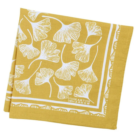 folded yellow bandana with white ginkgo pattern and 'Hearth & Harrow' branding on a white background