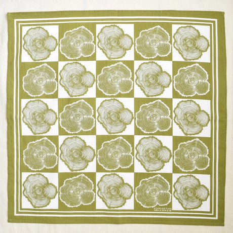 Square bandana with a pattern of tree rings on a green and white checkered background