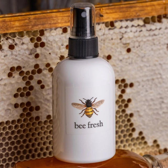 the Bee Fresh toner spray bottle; a white bottle with an illustration of a honey bee and text that reads "bee Fresh" with a black sprayer at the top of the bottle