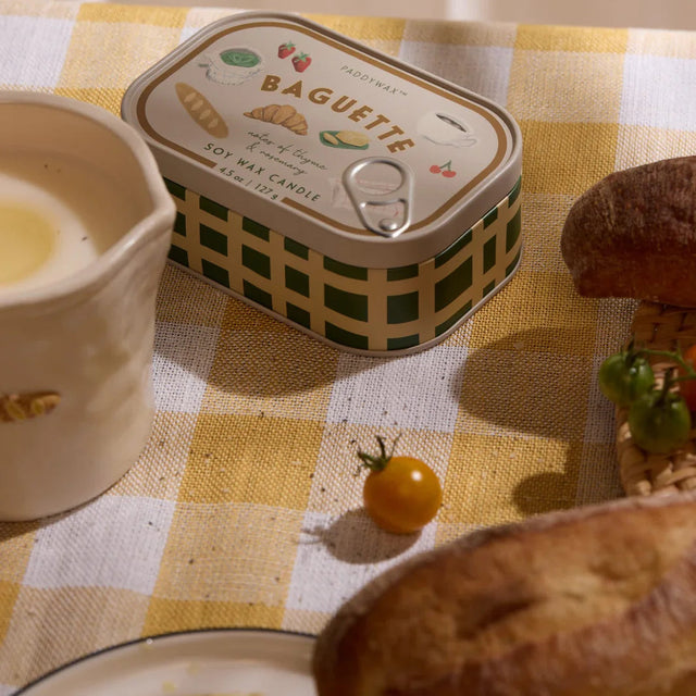 Can of 'Baguette' with a checkered tablecloth and bread on a table