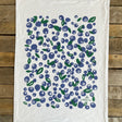 White towel with blueberry pattern on a wooden surface