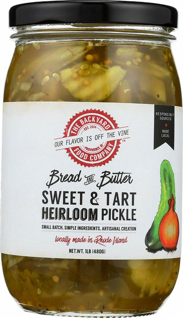A jar of The Backyard Food Company Bread & Butter Sweet & Tart Heirloom Pickle, showing the pickled vegetables inside the glass jar with a black lid and a white label featuring red and black text.