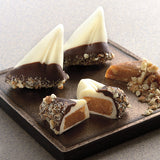 Dessert items with chocolate and caramel coatings on a dark surface