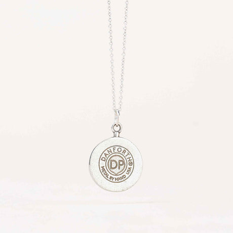 Back view of the Crescent Moon Necklace displaying the maker's mark stamped on the pewter, indicating the handcrafted quality of the piece
